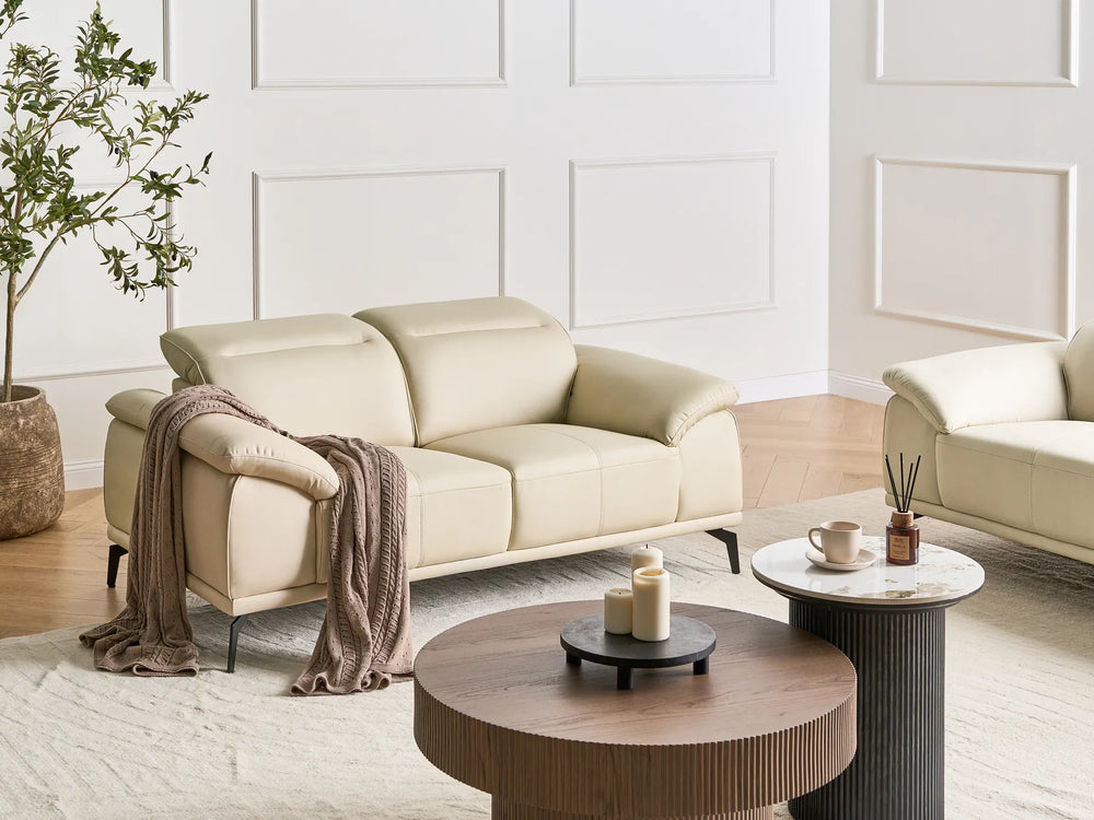 Beige sofa in a modern living room with wooden coffee table and decorative items.