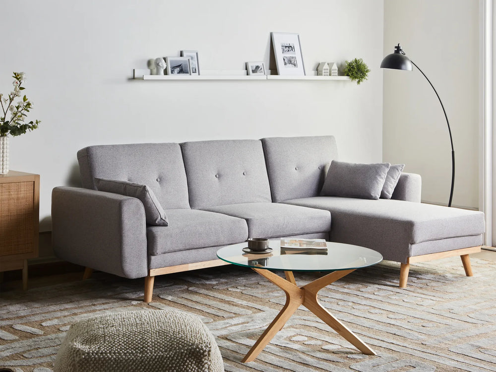 Gray sectional sofa in a modern living room with a coffee table and decorative items.