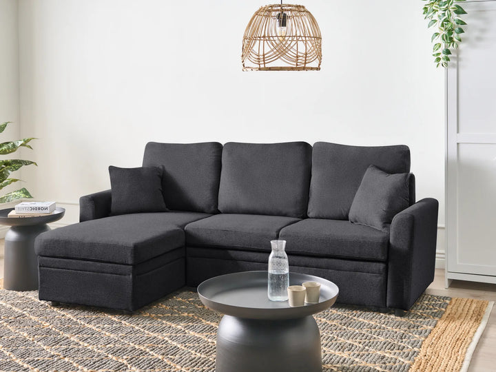 Gray sectional sofa in a living room setting with a coffee table and decor items.