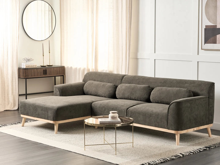 Gray sectional sofa in a living room setting with a coffee table and decorative items.