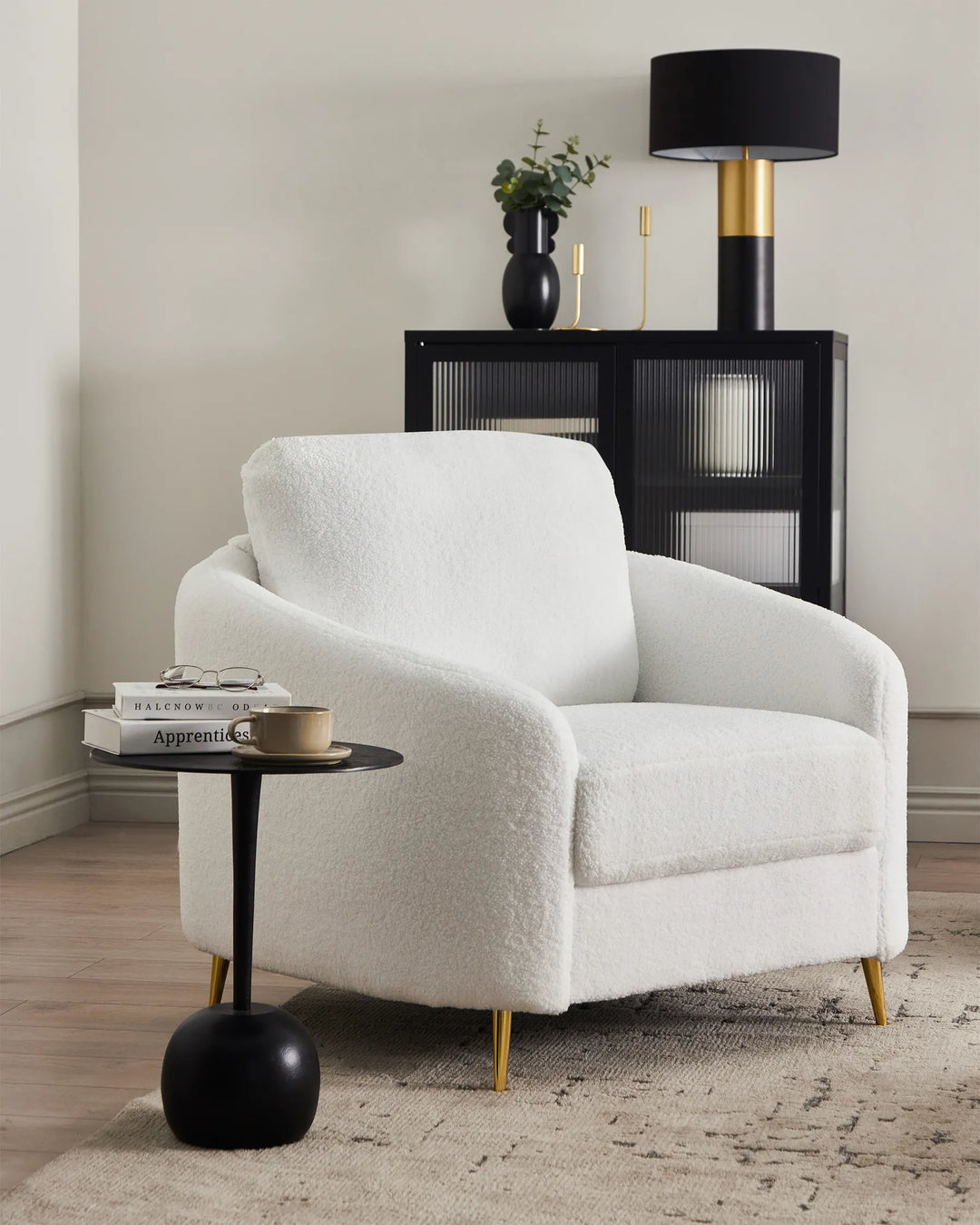 White armchair in a room with a side table and lamp