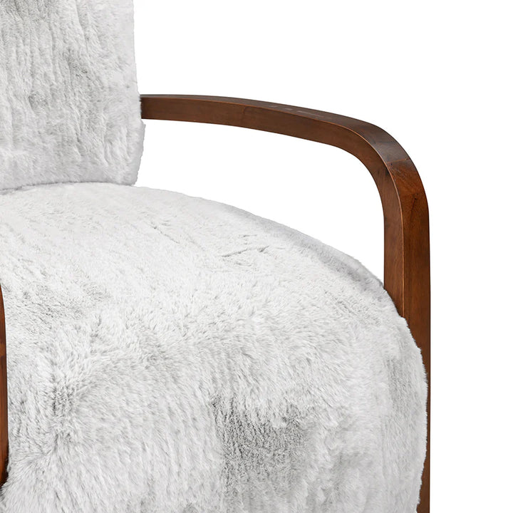 Close-up of a chair with white fluffy cushion and wooden armrest on a white background
