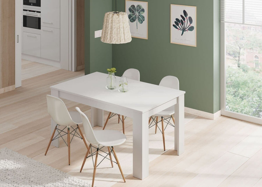 Modern dining area with a white table and chairs in a room with green walls and large windows.