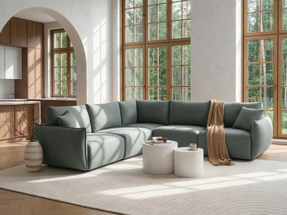 Modern living room with a gray sectional sofa, coffee table, and decorative items.