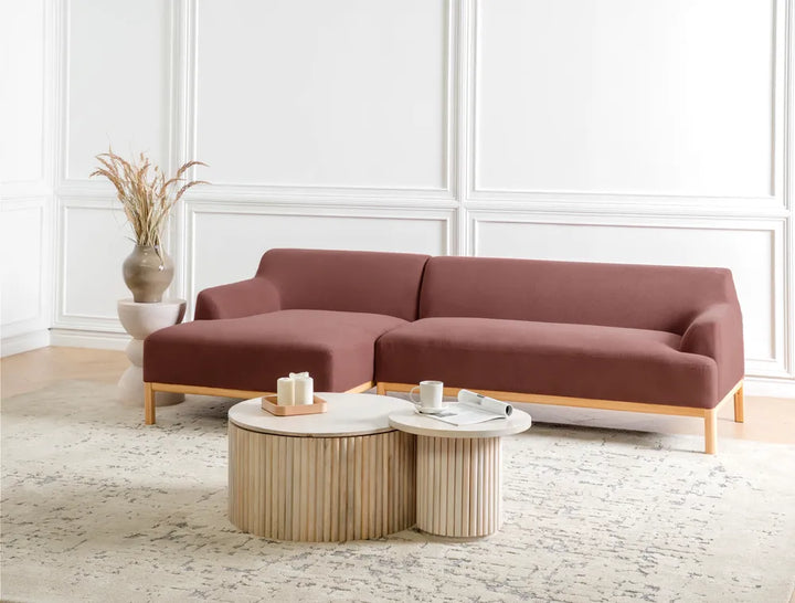 Brown sectional sofa in a living room with a coffee table and decorative items.