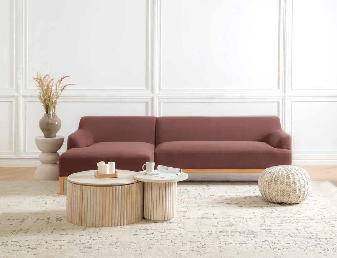 Brown sectional sofa in a living room with a coffee table and decorative items.