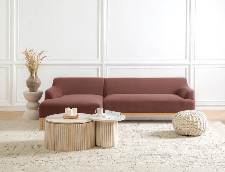 Brown sectional sofa in a living room with a coffee table and decorative items.