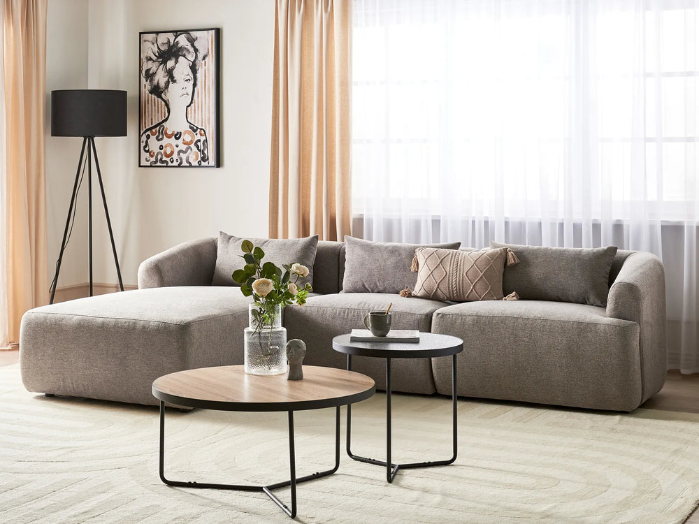 Modern living room with a gray sectional sofa, wooden coffee table, and decorative elements.