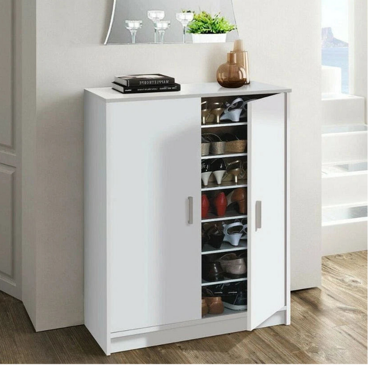 White cabinet with open doors displaying various items in a room with a mirror and decor.