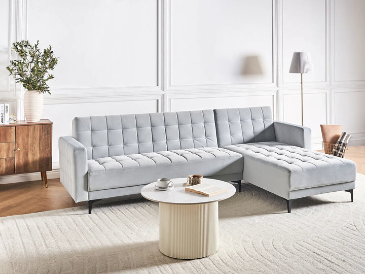 Gray sectional sofa in a modern living room with a coffee table and decorative items.