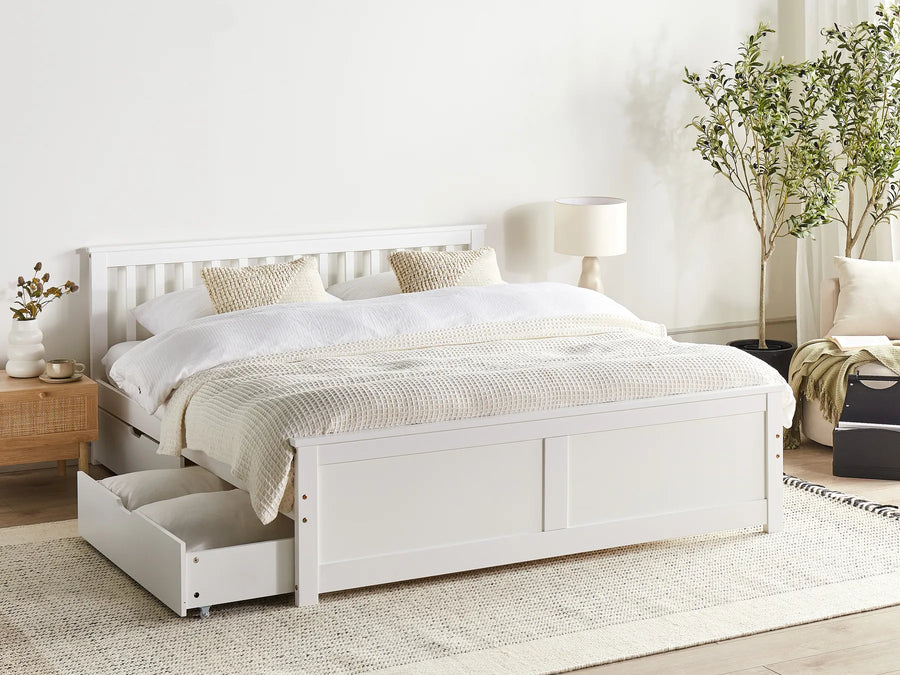 White bed with storage drawers in a bright bedroom setting