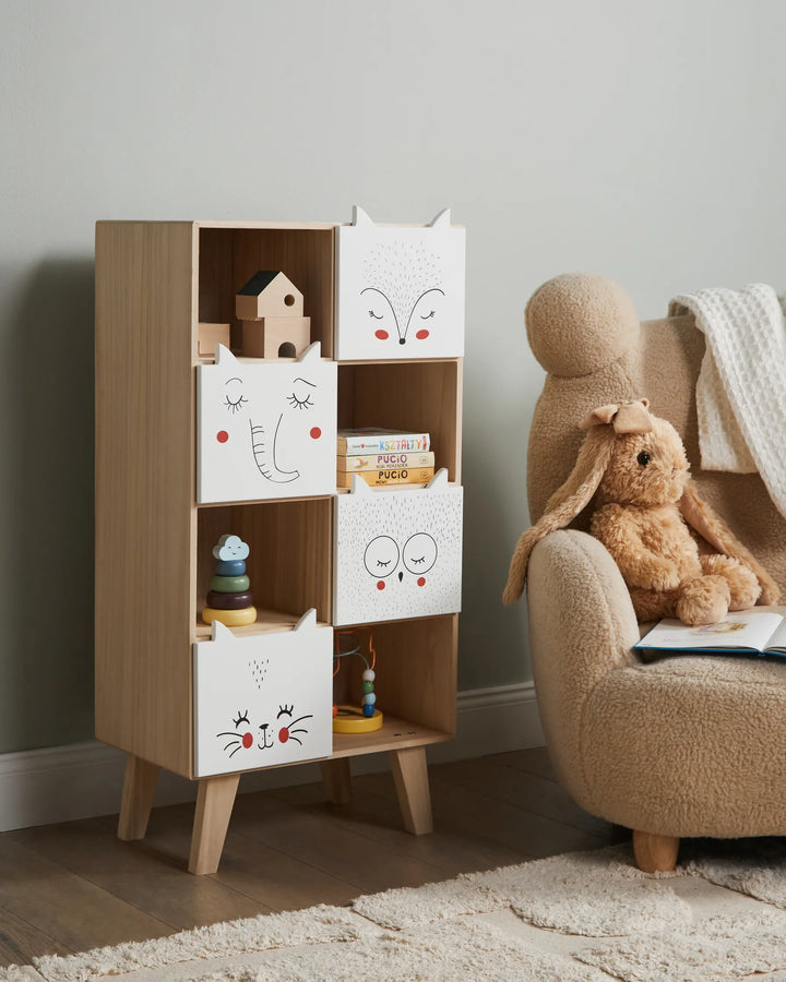 Children's room with wooden bookshelf and armchair featuring toys and books.