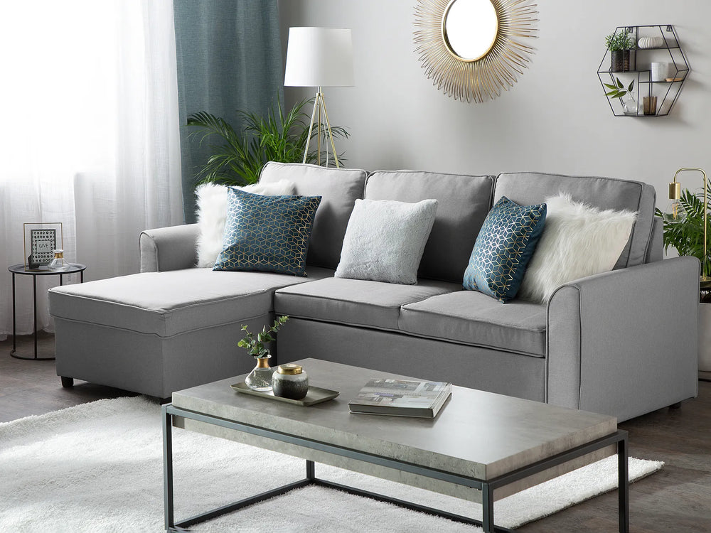 Gray sectional sofa in a living room with decorative pillows and a coffee table.