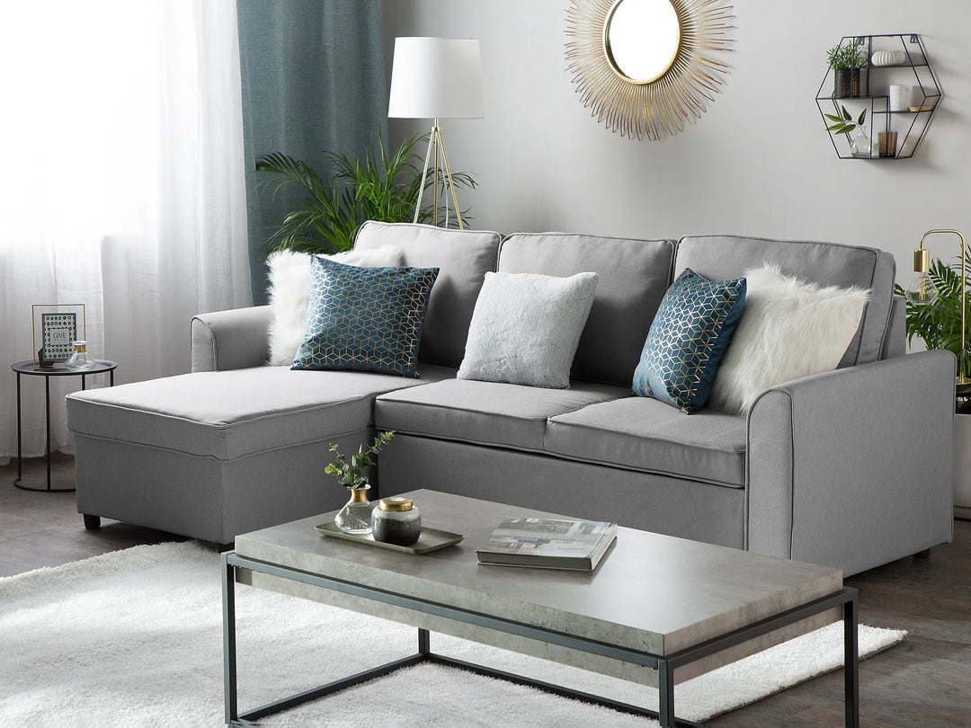 Gray sectional sofa in a living room with decorative pillows and a coffee table.