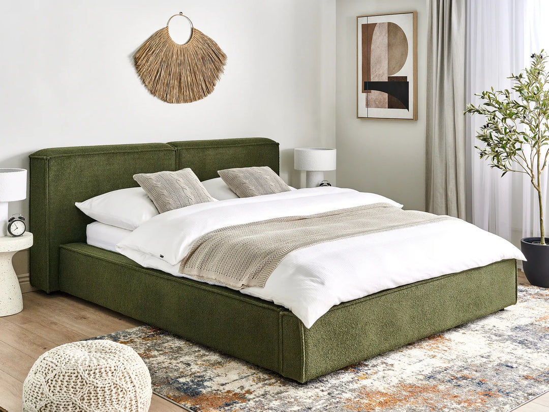 Green upholstered bed in a bedroom with white bedding and decor.