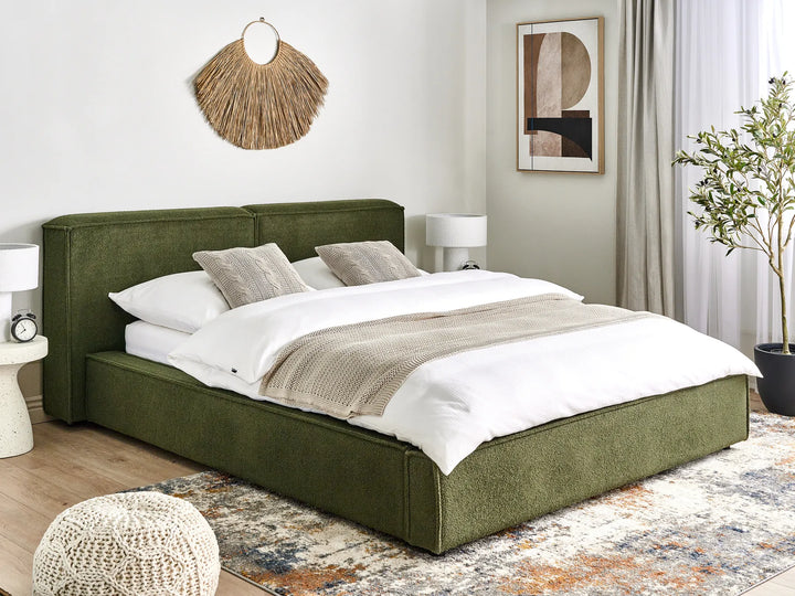 Green upholstered bed in a bedroom with white bedding and decor.