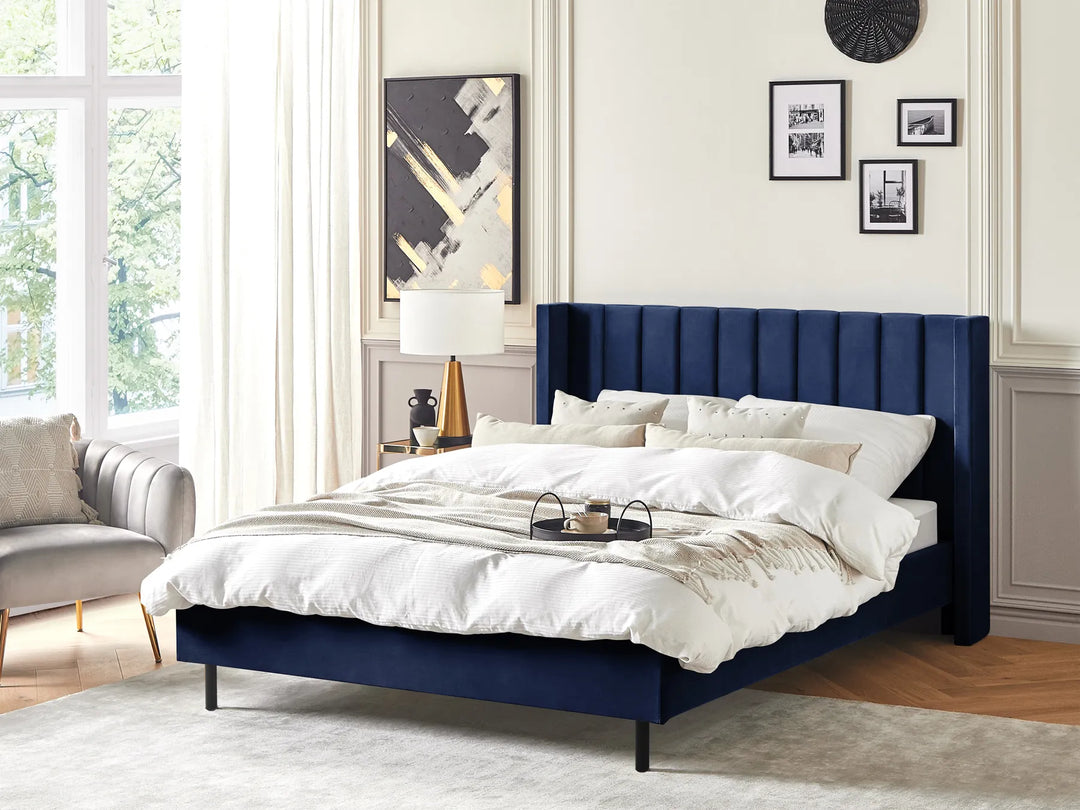 Navy blue bed with white bedding in a stylish bedroom