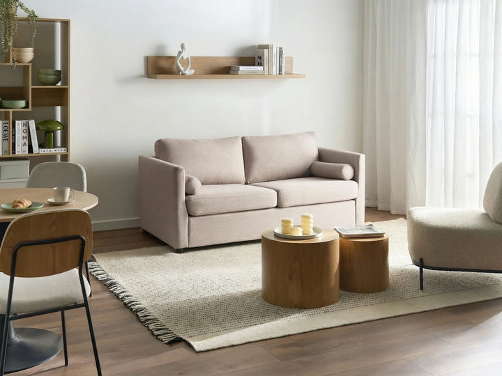 Modern living room with beige sofa, wooden coffee table, and chairs.
