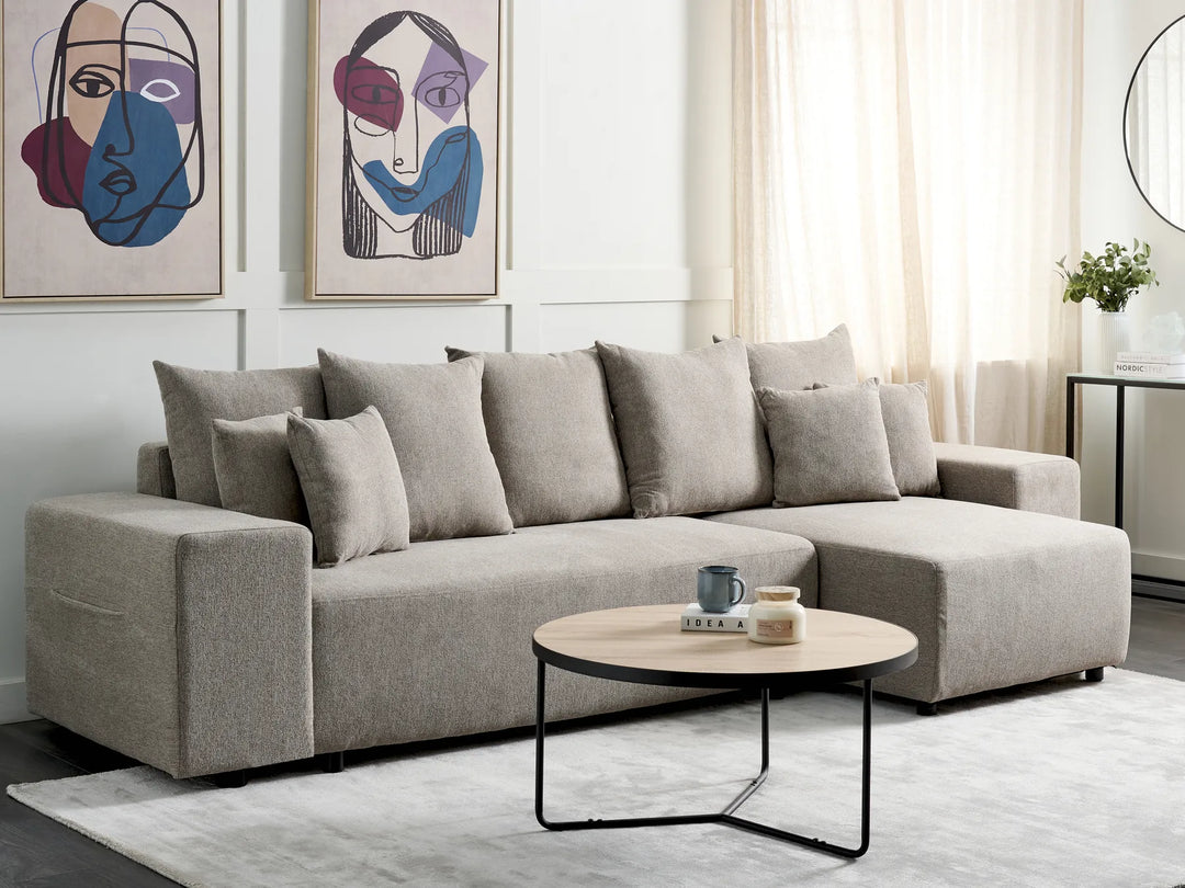 Gray sectional sofa in a living room with abstract art and a coffee table.