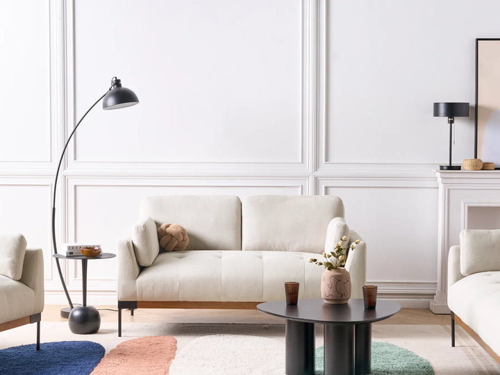 Modern living room with a white sofa, armchairs, and decorative elements.