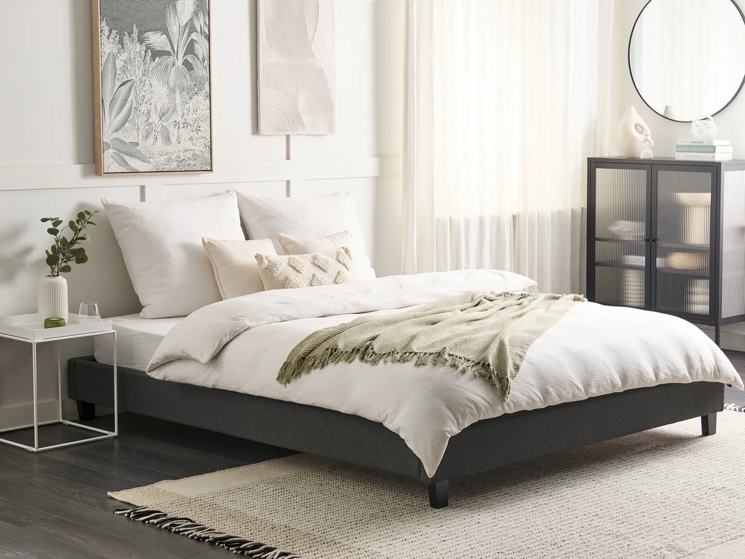Neatly made bed in a modern bedroom with decor elements.