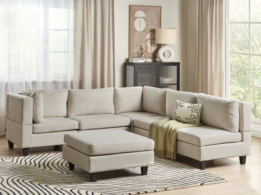 Beige sectional sofa with ottoman in a living room setting