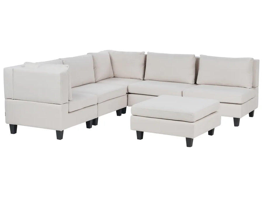 Beige sectional sofa with ottoman on a white background