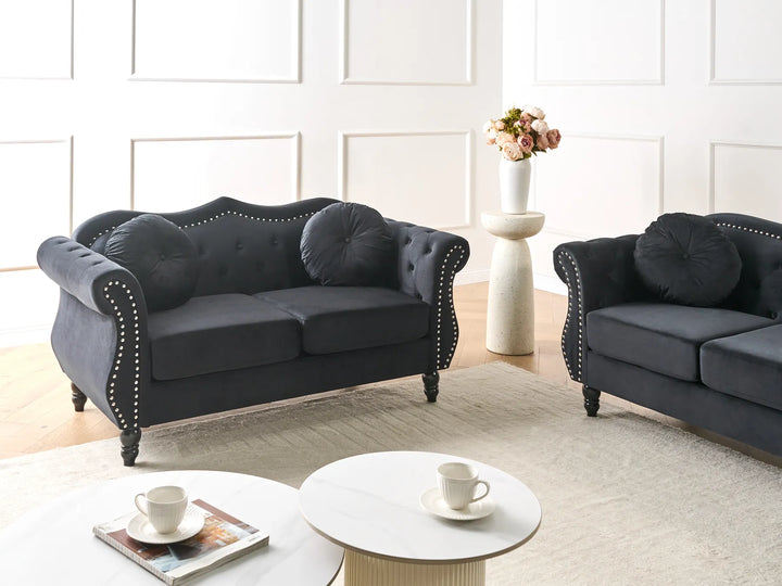 Two dark gray sofas in a living room setting with a coffee table and decorative items.