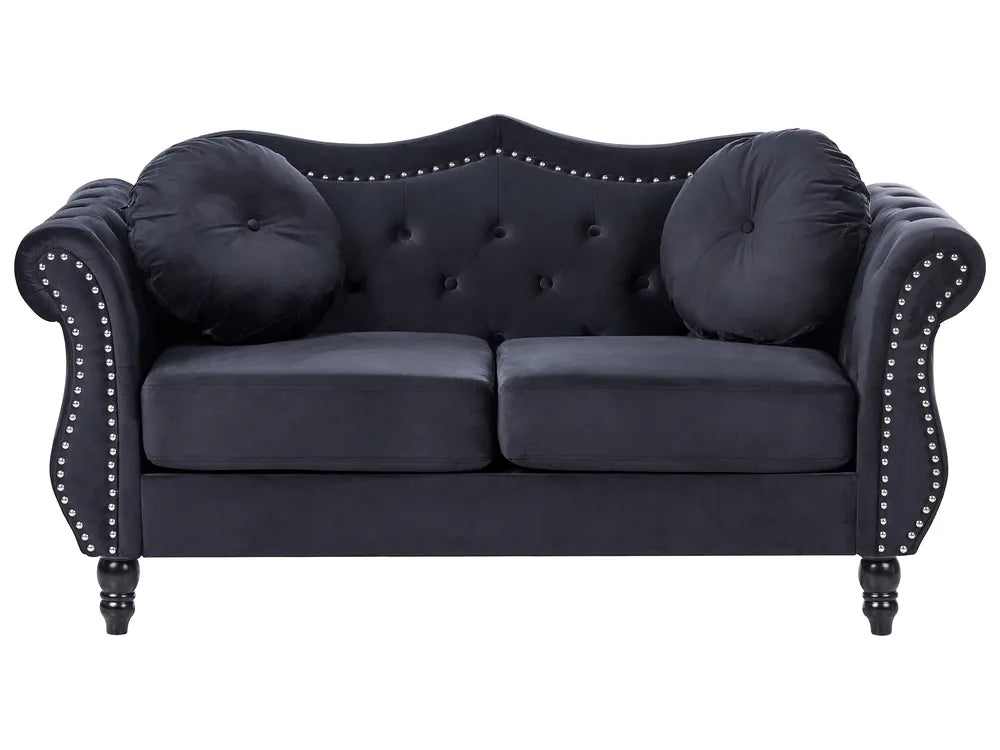 Navy blue sofa with tufted backrest and nailhead trim on a white background