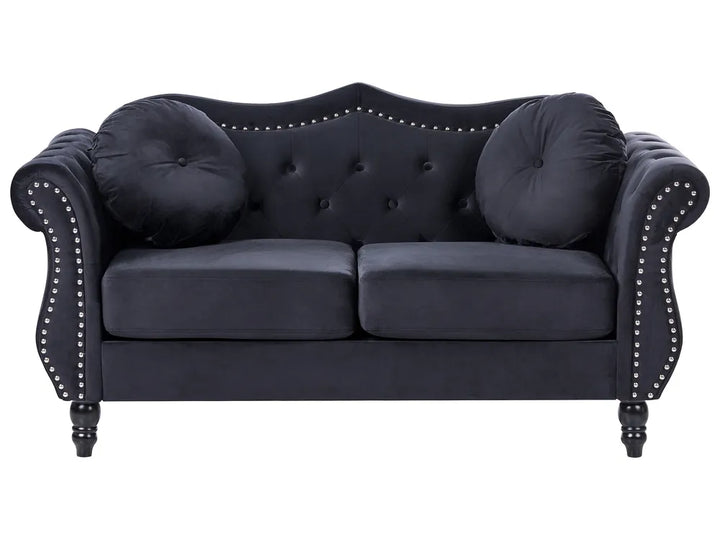 Navy blue sofa with tufted backrest and nailhead trim on a white background