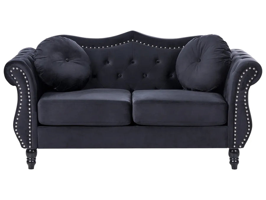 Navy blue sofa with tufted backrest and nailhead trim on a white background