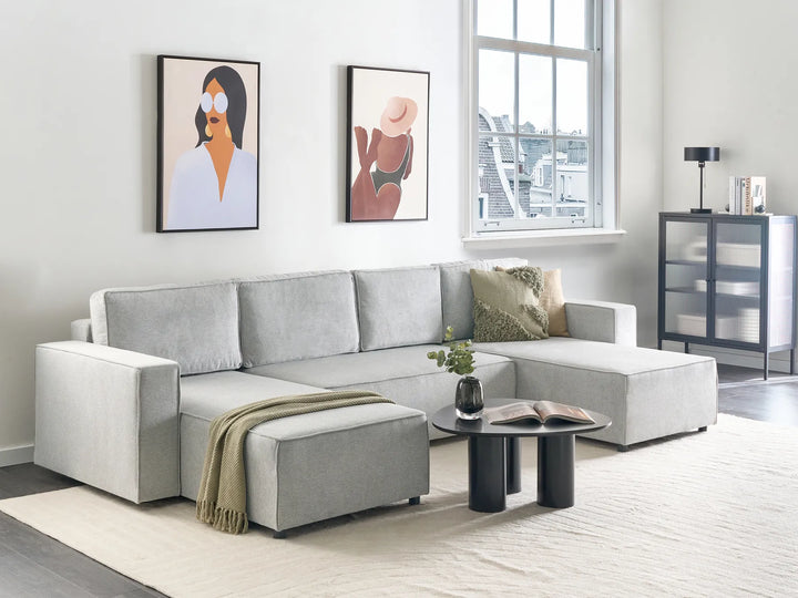 Modern living room with a gray sectional sofa, coffee table, and decorative items.