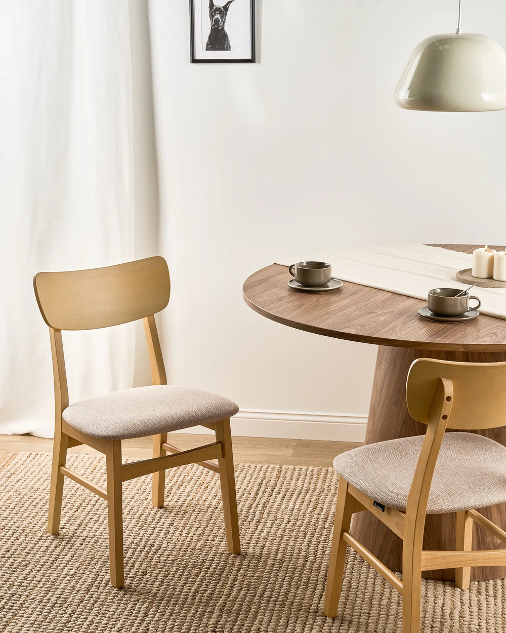 Natural wood woven dining chairs styled in a bright, cozy dining space with soft textures and warm neutral tones, creating an airy, inviting, and relaxed atmosphere.