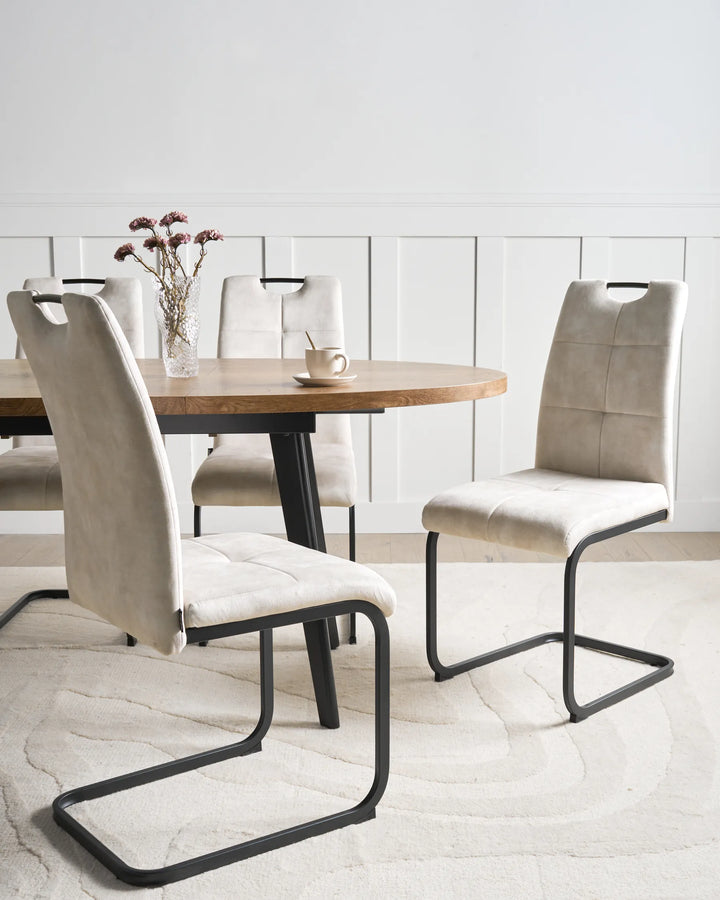 Modern dining chairs in a soft beige finish, paired with sleek black sled legs to create a comfortable and elegant dining space.