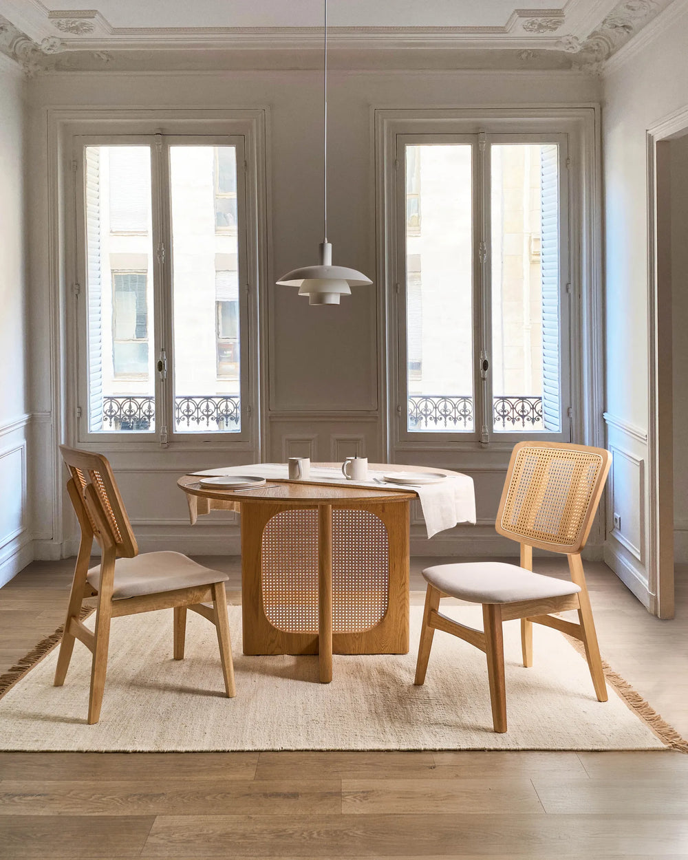 Styled within an elegant, light-filled dining space, this cane-back dining chair brings warmth and natural texture to the room. The combination of oak-toned wood, woven rattan detailing, and a neutral upholstered seat creates a relaxed yet refined aesthetic. Perfect for Scandinavian, coastal, and modern organic interiors, it offers comfortable seating while enhancing the dining area with timeless character and understated sophistication.