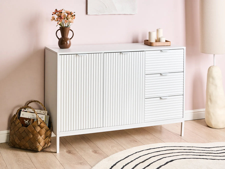 White cabinet with decorative items against a pink wall