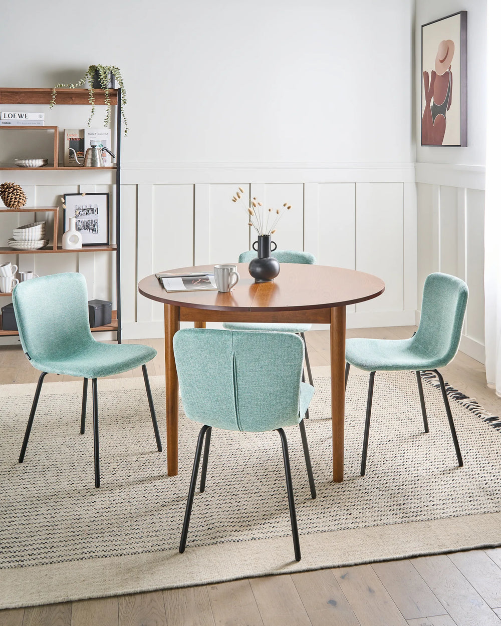 Mint green dining chairs arranged around a wooden table in a bright, contemporary dining room.