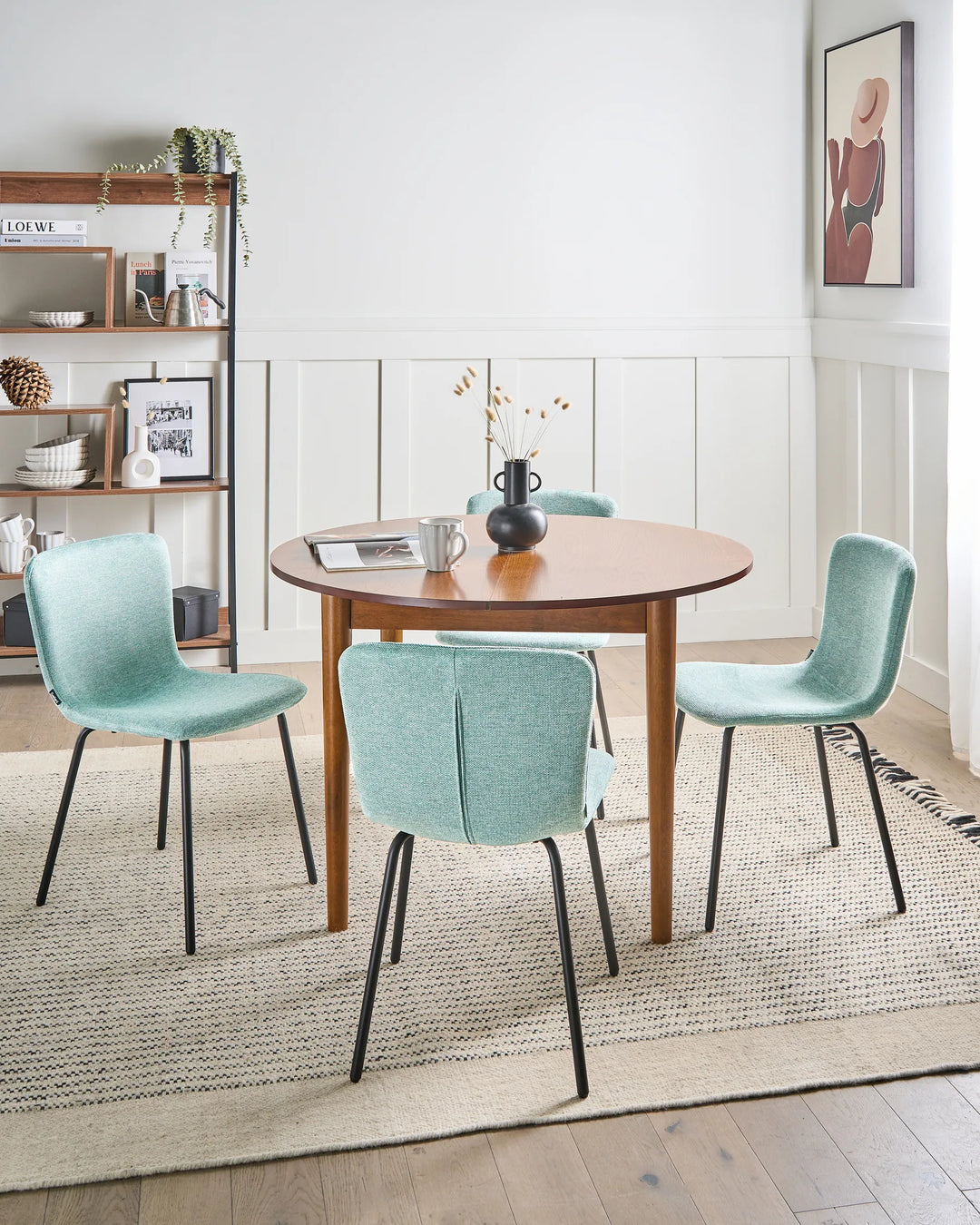 Mint green dining chairs arranged around a wooden table in a bright, contemporary dining room.