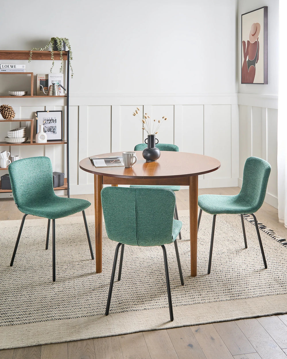 Green dining chairs styled around a wooden table in a bright, modern dining room.