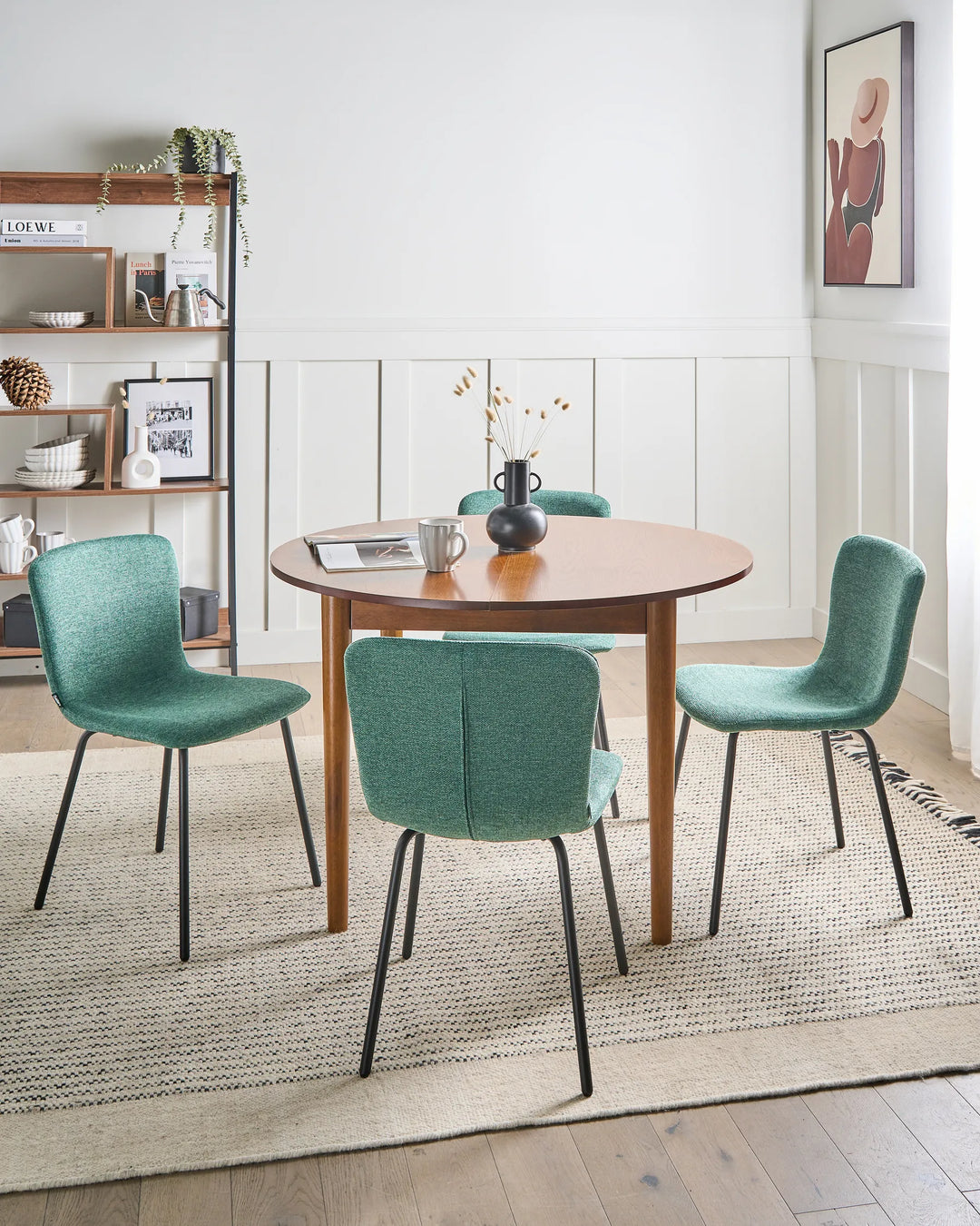 Green dining chairs styled around a wooden table in a bright, modern dining room.