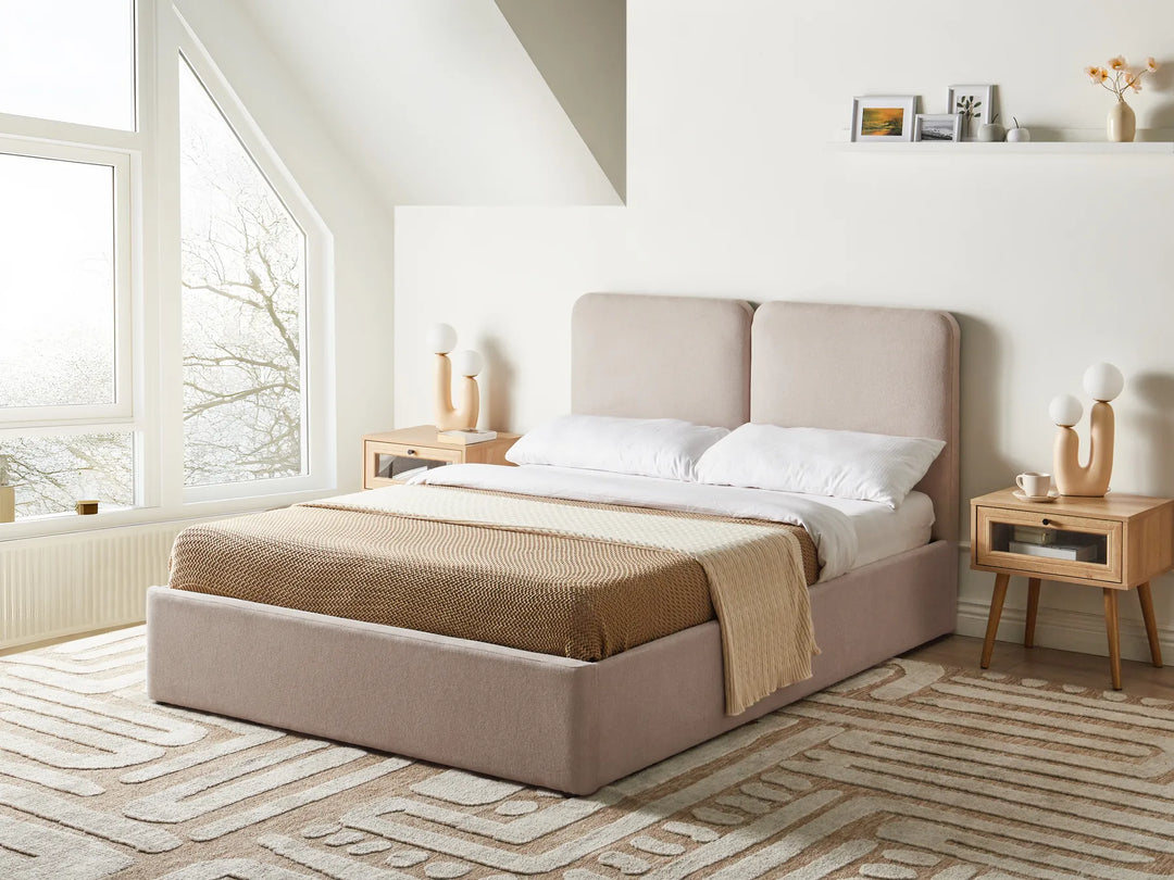Beige upholstered bed in a bright bedroom