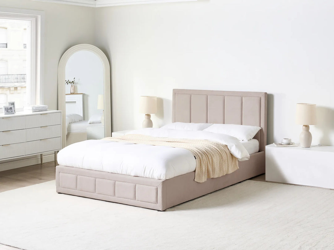 Neatly made bed in a bedroom with a dresser and mirror.