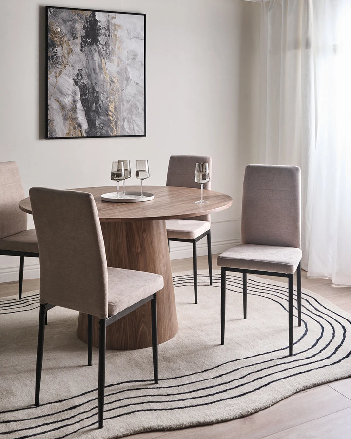 Taupe dining chairs around a round wood table in a modern dining room with soft neutral tones.