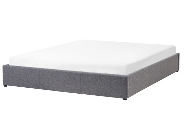 Gray upholstered bed frame with white mattress on a white background