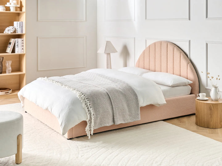 Pink bed with white bedding in a bright bedroom