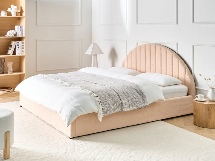 Neatly made bed with a wooden headboard in a bedroom setting.