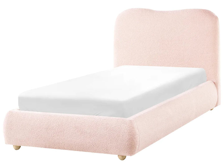 Pink upholstered bed with white mattress on a white background