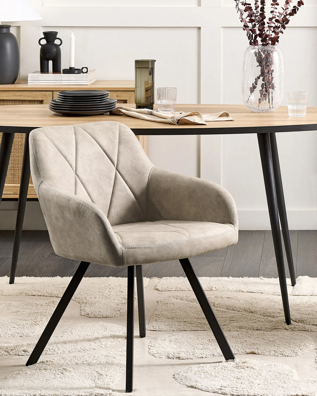 Elegant dining setting showcasing the taupe-grey accent chair paired with a natural wood table and black metal accents, creating a warm, modern, and inviting atmosphere.