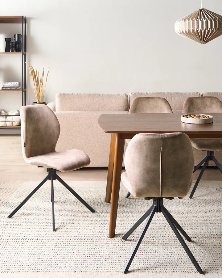 Taupe faux leather swivel dining chairs around a walnut dining table with a beige sofa, shelving, pendant light, and cream rug.