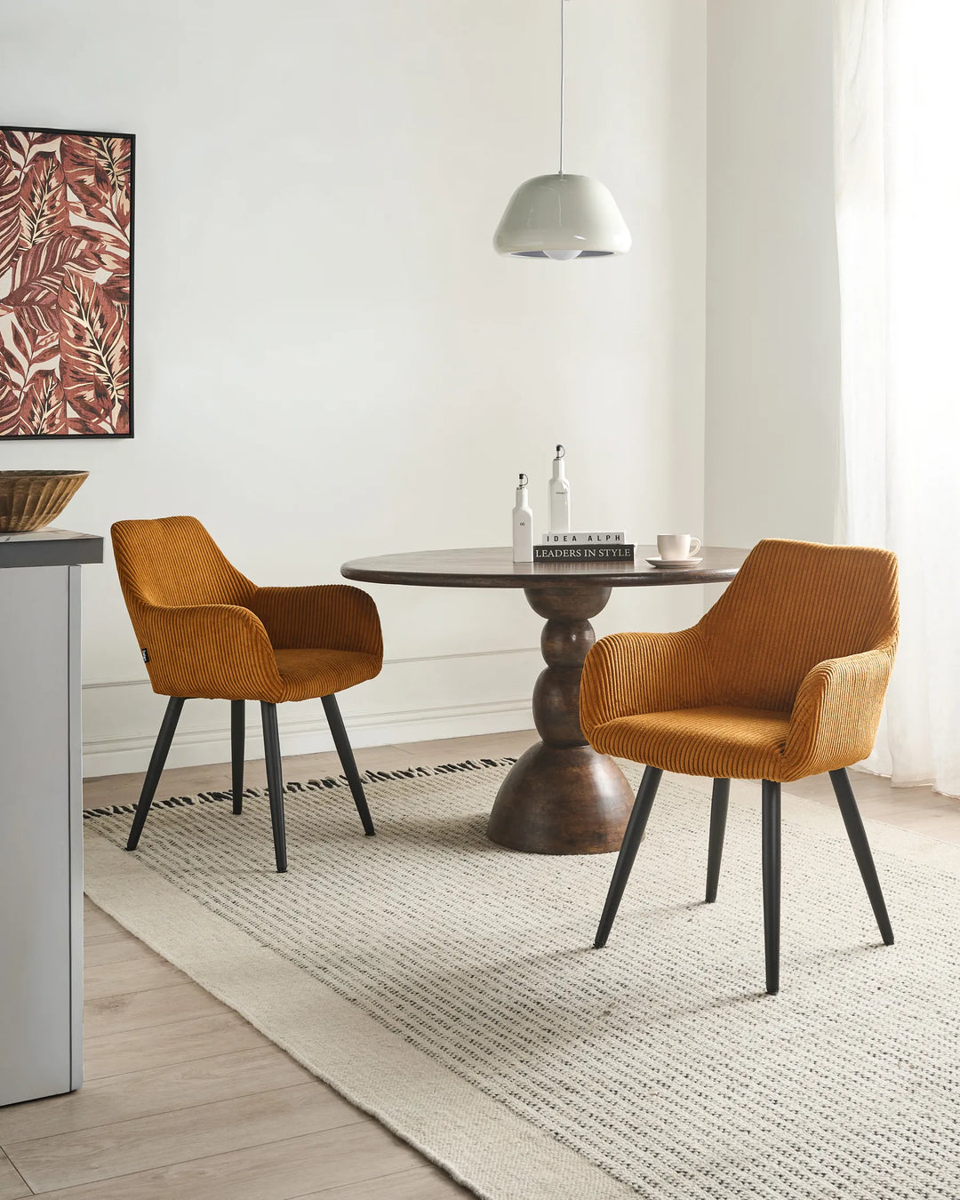 Modern mustard orange dining chairs styled around a dark wood table in a cozy contemporary dining room.